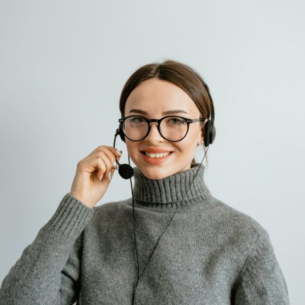 Friendly customer support woman smiling while wearing a headset in the office.
